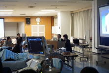 心エコーセミナーのセッション中、講師がプレゼンテーションを行い、受講者が聴講している様子。