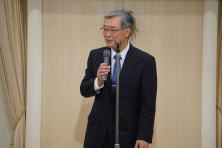 福島県地域医療症例検討会で講演する男性がマイクを持って話している様子。