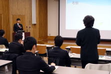 福島県立医科大学で行われた地域医療症例検討会の様子。講演者がプレゼンテーションを行い、聴衆が注目している。