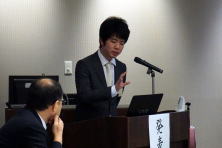 研修医の小河原峻先生が講演を行っている様子。会場には聴衆が座っている。