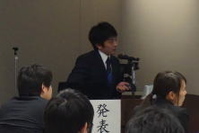 研修医が発表を行っている様子。聴衆が注目している会議室の風景。