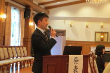 研修医が発表を行っている様子。会場は明るく、椅子が並んでいる。
