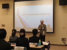 福島県地域医療症例検討会で講演する男性と聴衆の様子。