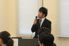 研修医の山口大二郎先生が講演を行っている様子。聴衆が真剣に聞き入っている。