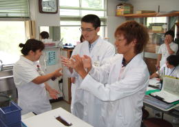 医療体験プログラムに参加する学生たちが、実習室で手洗いの指導を受けている様子。