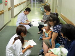 医療体験プログラムの一環で、医師と患者が対話している病院の廊下の様子。