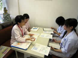 医療現場での研修中、医師と学生が資料を見ながら話し合っている様子。