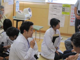 医療体験プログラムに参加する学生たちが、患者の話を聞きながらディスカッションしている様子。
