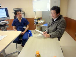 医療現場での体験プログラム中、医師と参加者が話し合っている様子。