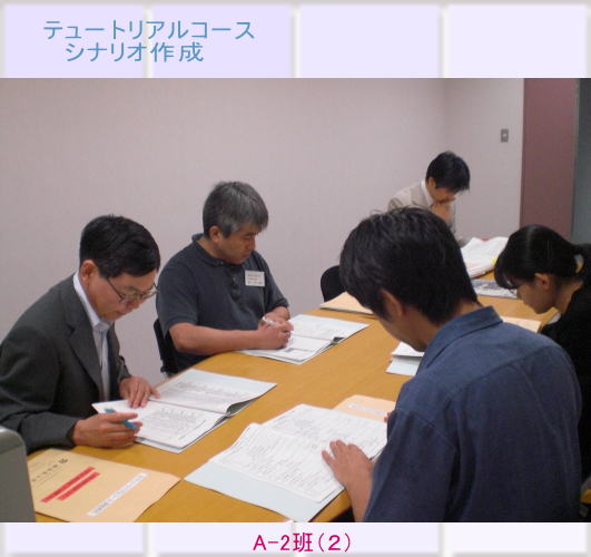 テュートリアルコースのシナリオ作成に取り組む参加者たちが、資料を見ながら議論している様子。