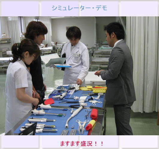 医療シミュレーターのデモンストレーション中、医学生と講師が器具を確認している様子。