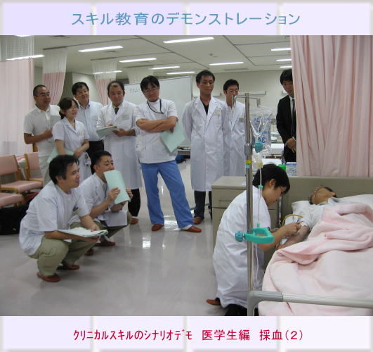 医学生が患者の採血を行うデモンストレーションの様子。周囲には指導者や他の学生が見守っている。
