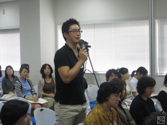 福島県立橘高等学校での出前講座中、質問をする男性と参加者たちの様子。