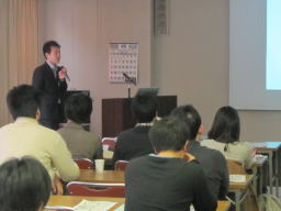福島県立医科大学での講演会の様子。講師が参加者に向けて話している。