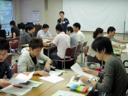 福島県立医科大学の教室で、参加者がグループ活動を行いながらアイスブレイクを楽しんでいる様子。