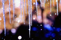 氷柱が垂れ下がる冬の風景、背景にはぼんやりとした光が広がる。