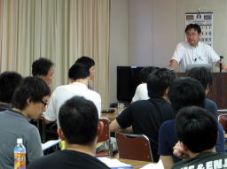 福島県立医科大学での講義中の参加者たちが、講師の話を真剣に聞いている様子。
