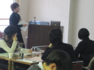 福島県立医科大学の講義中、参加者が真剣に聞き入る様子。講師がプレゼンテーションを行っている。