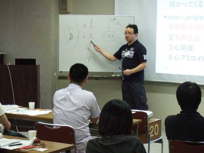 福島県立医科大学での講義中、ホワイトボードを指し示す講師と参加者たちの様子。