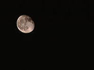 夜空に浮かぶ明るい満月の画像。暗い背景に対して月のクレーターがはっきりと見える。