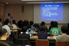 福島県立医科大学での研修中、参加者が講義を受ける様子。スライドには「つつが虫病」についての情報が表示されている。