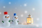 雪だるまが並び、温かい光を放つランタンの前で冬の夜を楽しむ様子。