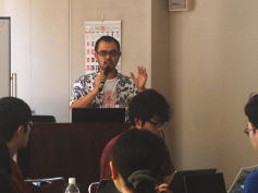 福島県立医科大学の講義で話す講師と、参加者が真剣に聞いている様子。