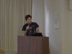 福島県立医科大学の講演会で話す参加者、背景にはカーテンと掲示板が見える。