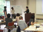 第1回診断推論セミナーで参加者が意見を交わしている様子。講師がホワイトボードを使って説明している。
