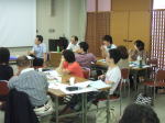 第1回診断推論セミナーで参加者が講義を受けている様子。テーブルには資料や飲み物が置かれ、参加者は真剣に話を聞いている。