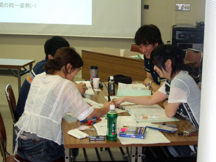第1回診断推論セミナーで参加者がグループで話し合いをしている様子。テーブルには資料や文房具が散らばっている。