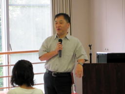 第3回診断推論セミナーで講演を行う男性がマイクを持ち、参加者に向かって話している様子。