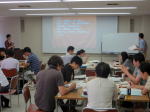 第4回診断推論セミナーで参加者がグループディスカッションを行っている様子。講師がプレゼンテーションを行い、参加者が熱心にメモを取っている。