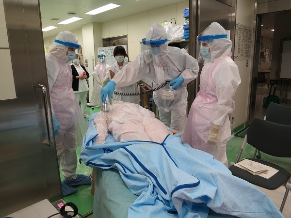 医療研修会での緊急被ばく対応訓練の様子。防護服を着た医療スタッフが患者に対応している。