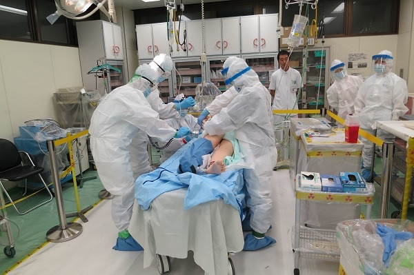 医療現場での緊急処置を行う医療スタッフが、患者に対して手当をしている様子。