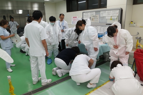 院内緊急被ばく医療研修会で、医療従事者が防護服を着用し、実習を行っている様子。