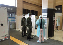 医大病院の玄関で、放射線スクリーニングを受ける来院者と医療スタッフ、及び自衛隊員の様子。