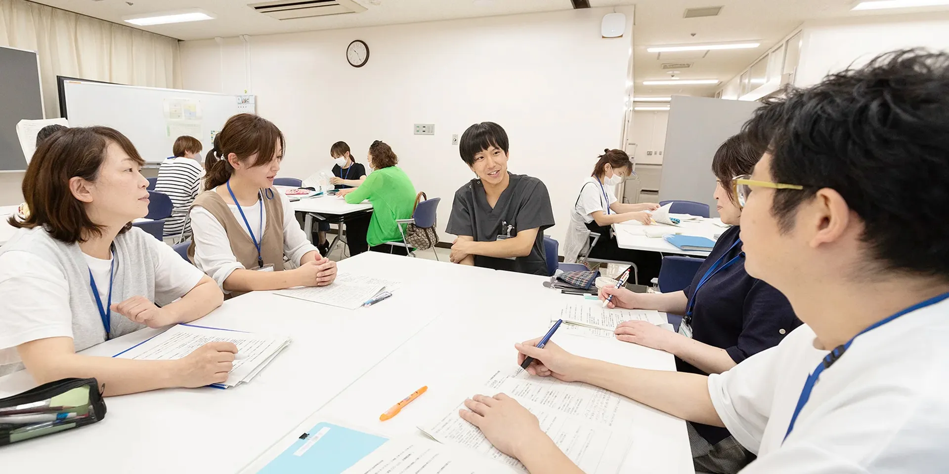 看護師特定行為研修センターでの研修中、参加者がテーブルを囲んで話し合っている様子。