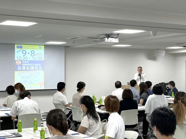 令和6年度看護師特定行為研修指導者講習会の様子。講師が前で説明し、参加者が聴講している。