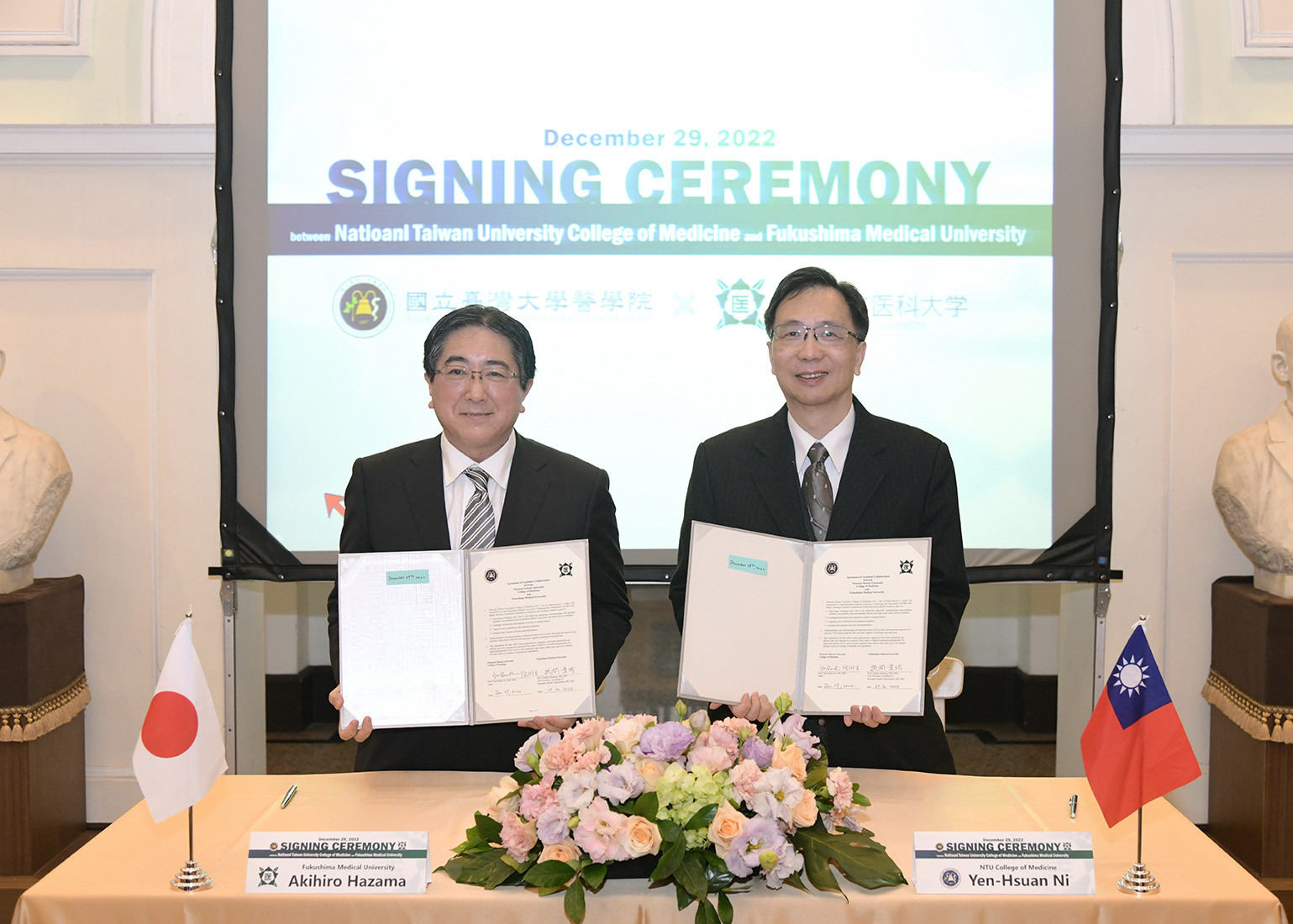 国立台湾大学医学院との学術交流協定締結式で、挾間章博副理事長と倪衍玄医学院長が書類を持っている様子。