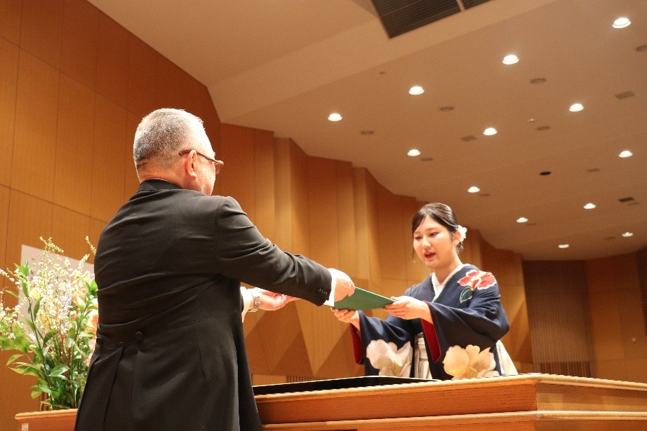 学位記授与式で卒業生が学位記を受け取る様子。