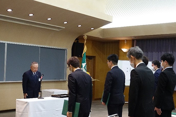 大学院の学位記授与式でスピーチをする竹之下学長と、参加者たちがの様子。