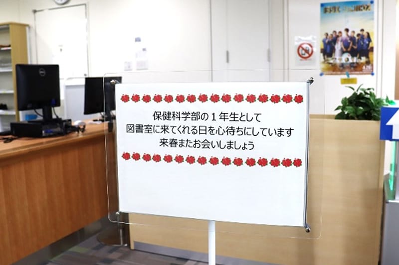 図書室内に設置された看板で、保健科学部の1年生を春に迎えるメッセージが書かれている。