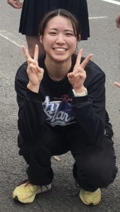 ピースサインをして笑顔を見せる若い女性