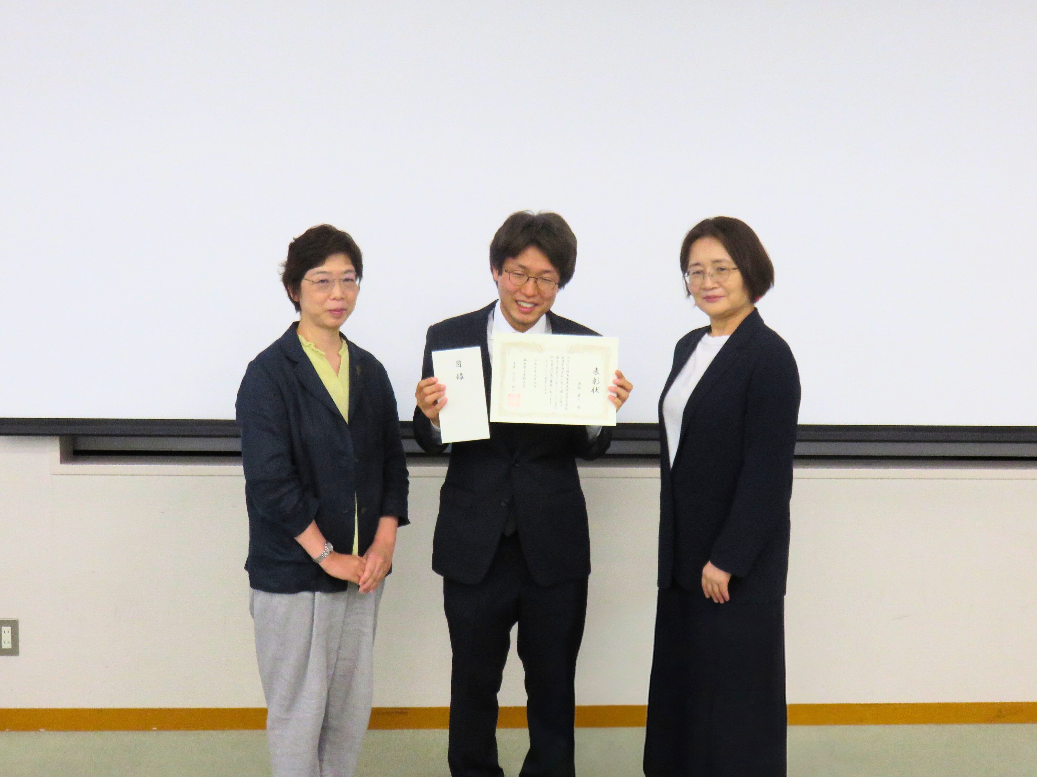 大学院看護学研究科の修士論文研究発表会で発表を行う学生と聴衆の様子。
