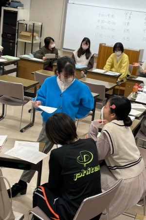 老年看護学の授業中、学生たちがグループで話し合いをしている教室の様子。