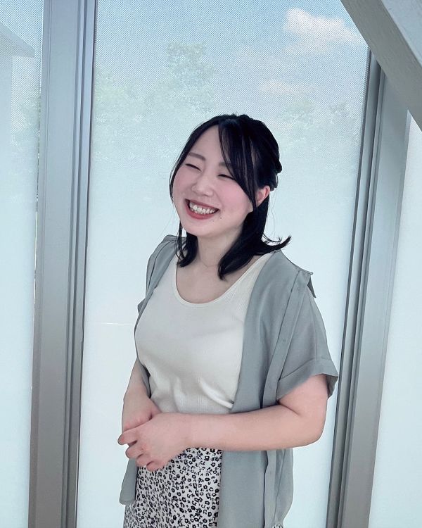 リラックスした雰囲気で明るく笑顔で立つ宗像花さんの写真。
