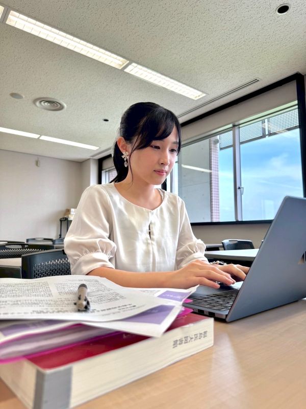 教室の一角でノートパソコンに向かい集中している村田呼春さんの写真。