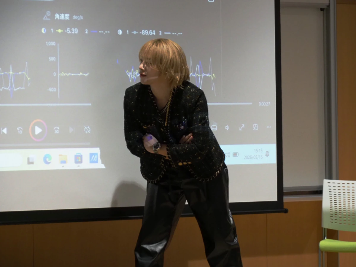 席を立ちグラフを見つめる本田さん