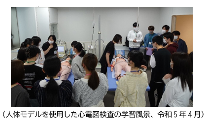 医療技術を学ぶ新1年生たちが、人体モデルを使って心電図検査の実習を行っている様子。